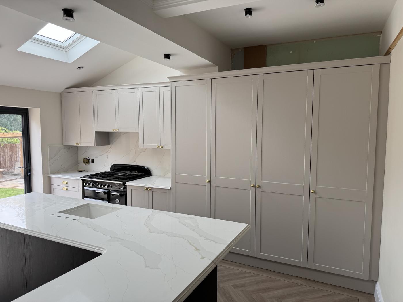 Light grey shaker kitchen with range cooker and floor-to-ceiling units