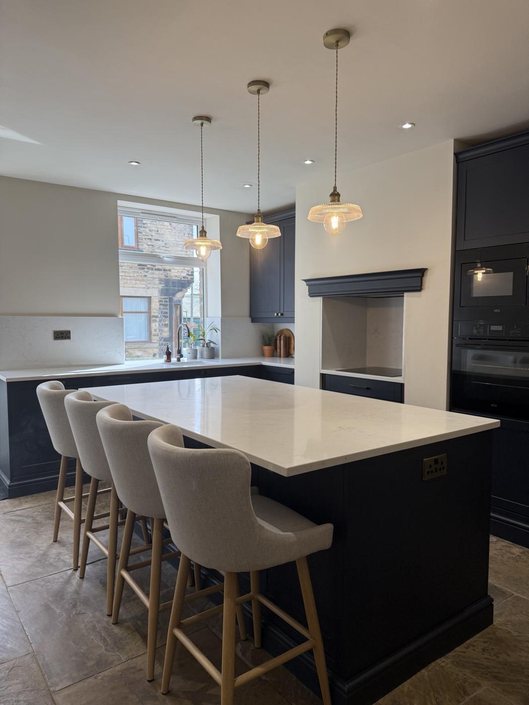 Navy shaker kitchen with a large island, quartz worktop and built-in ovens